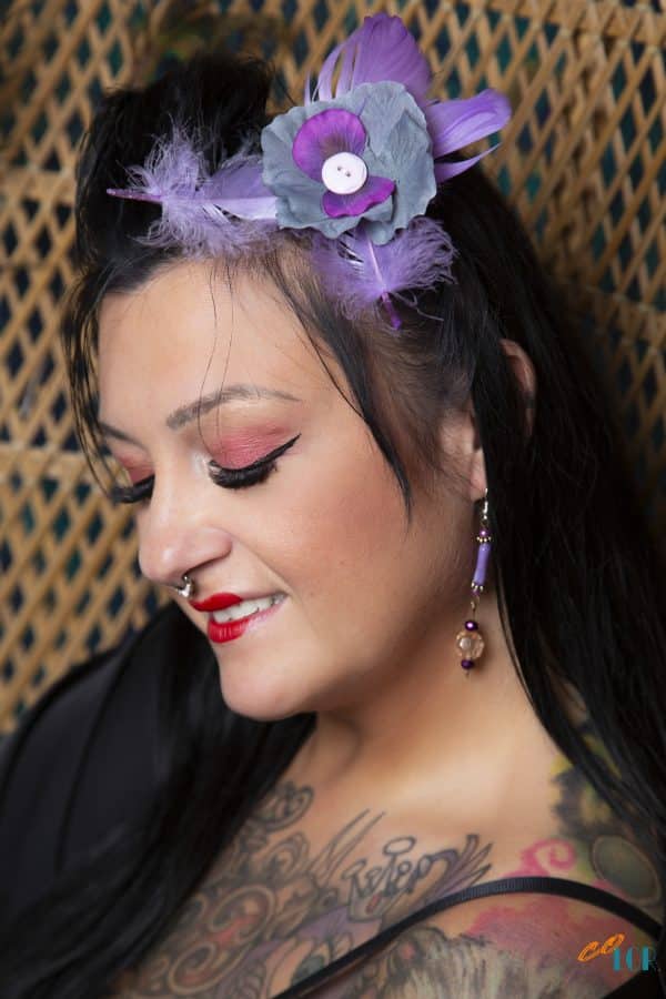 Pince à cheveux porter par une mannequin style gaisha elle porte une pince à cheveux en forme de fleur et de plume de couleur mauve