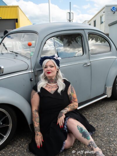 Bonnet en coton bleu avec une fleur sur le cote une orchidee blanche avec un bouton bleu dans une voiture coccinelle