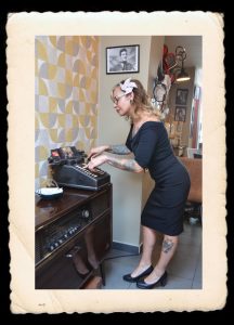 Mis en pahe de la page de contact avec une mannequin qui tappe a la machine à ecrire dans un esprit pin up