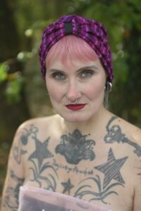 Bonnet turban en jersey imprimé à lignes rose, violet et noir, avec ruban noir sur le devant